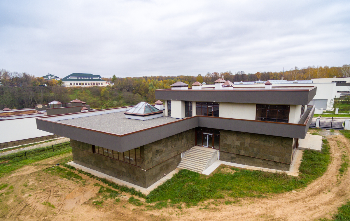 A contemporary villa with clean architectural lines, large glass windows, and landscaped surroundings.
