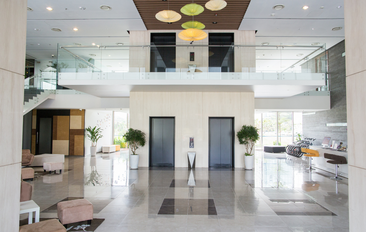 Modern building lobby with elevators, seating area, and reception desk